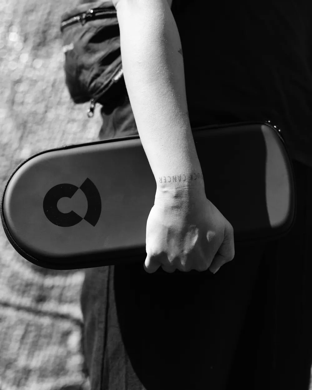Eine Hand hält das schwarze Coturn Case mit dem Coturn-Zeichen